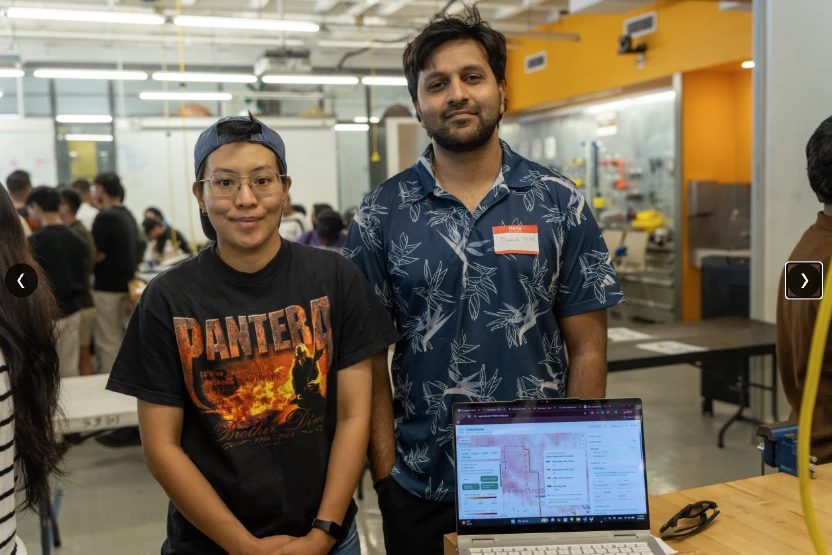Devansh Patel and Chidchanok Pleesudjai at a laptop running CarbonLens on the floor of Innovation Hacks 2.0